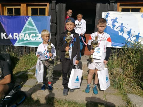 Leon z pucharem wśród nagrodzonych dzieci przed schroniskiem