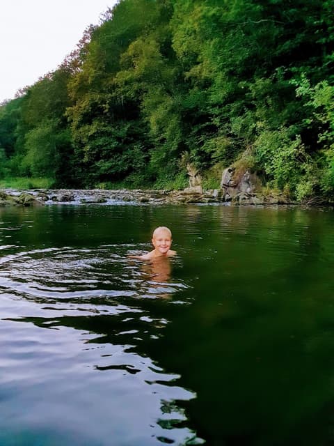 Leon kąpie się w rzece pod ścianą lasu