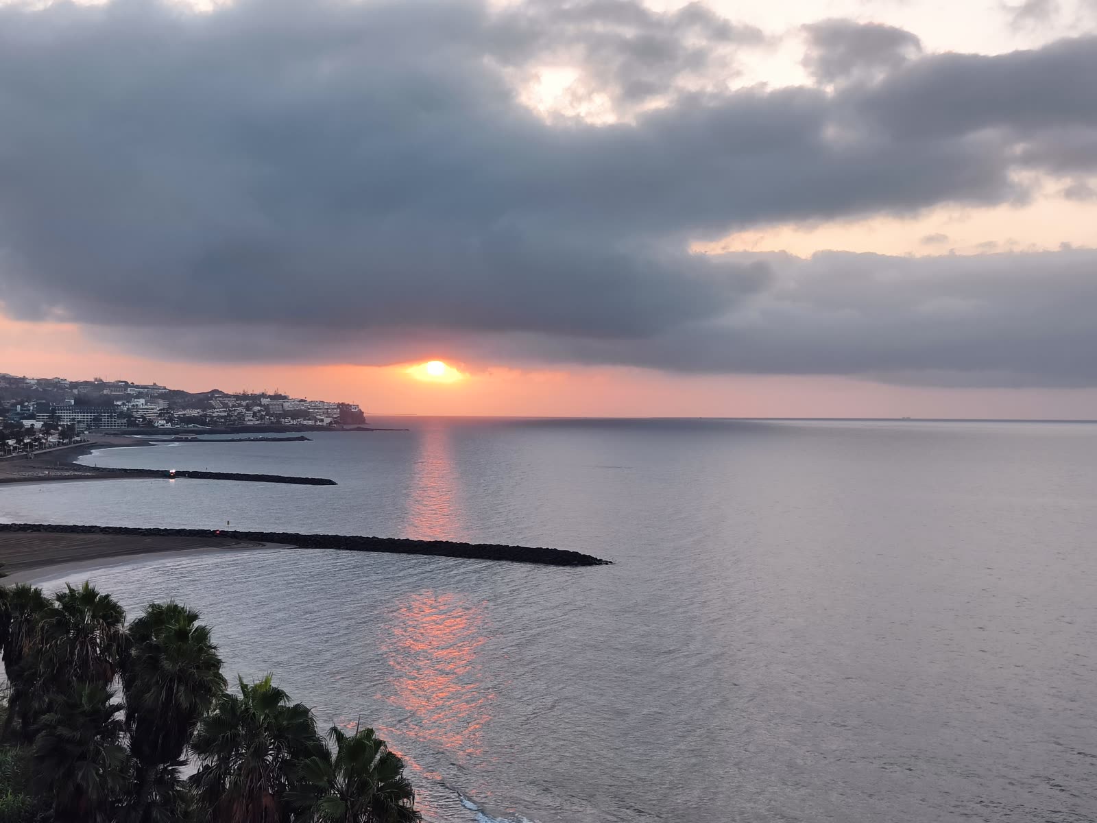 Wschód słońca nad oceanem, w dole palmy i wybrzeże