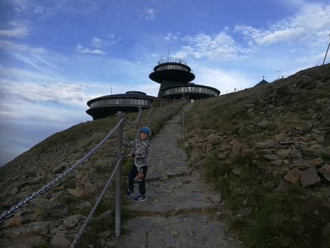 Leon na schodach pod obserwatorium na Śnieżce o zmierzchu