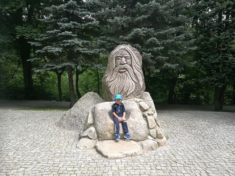 Leon siedzi pod kamienną rzeźbą Ducha Gór