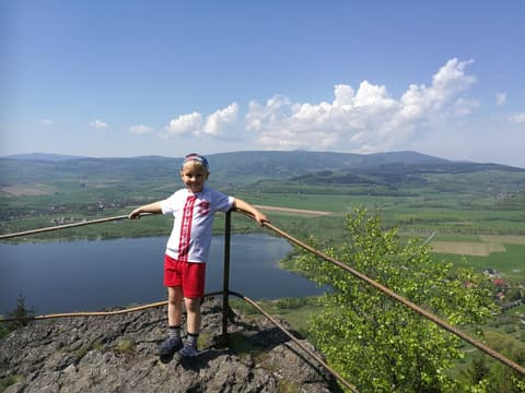 Leon przy barierce nad zalewem, w tle szerokie pola