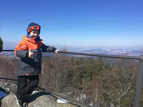 Leon przy barierce punktu widokowego nad zimową kotliną