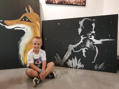 Leon siedzi przy obrazach lisa i Małego Księcia