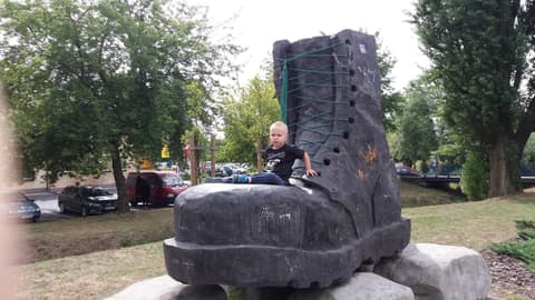 Leon siedzi na wielkim betonowym glanie w Jarocinie