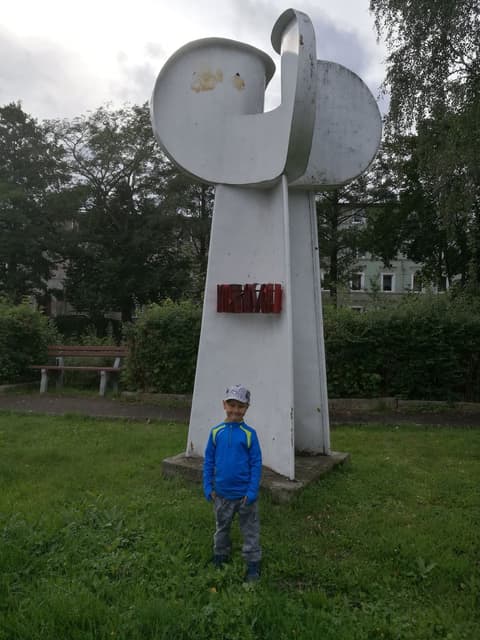 Leon przy betonowym pomniku w miejskim parku